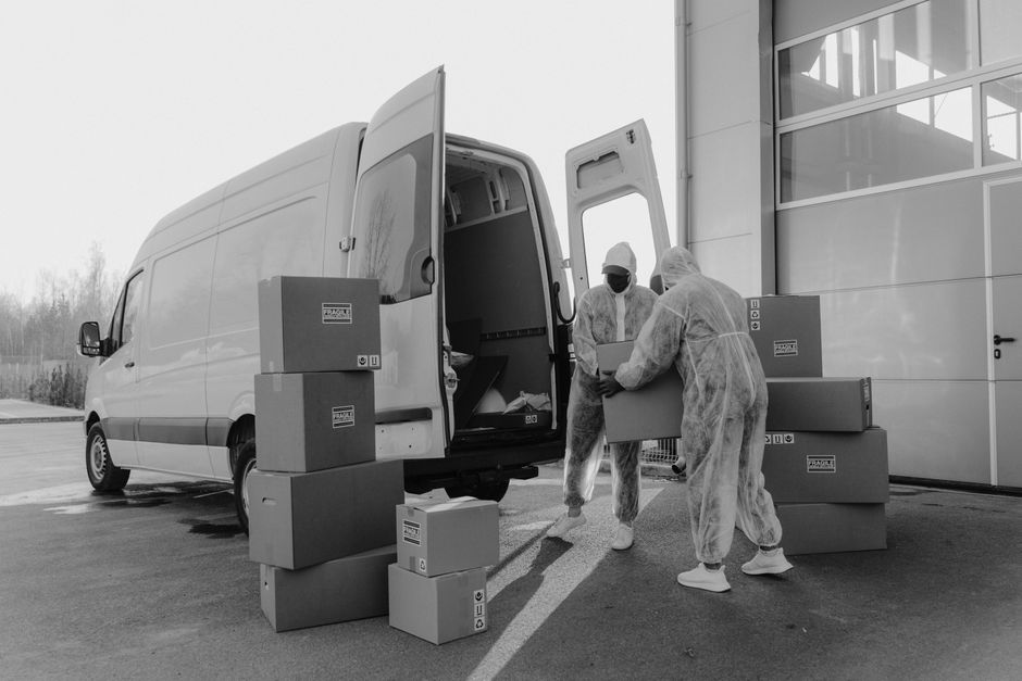 Zwei Möbelpacker tragen gemeinsam einen Karton
